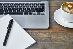 Laptop Notepad And Coffee Cup On A Work Desk